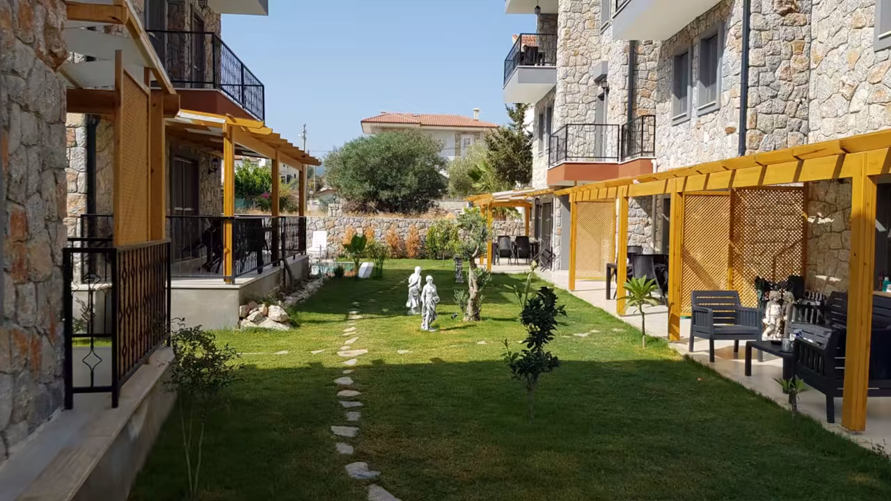 Villa Nora yapıları arasındaki yeşil bahçe ve açık yaşam alanları