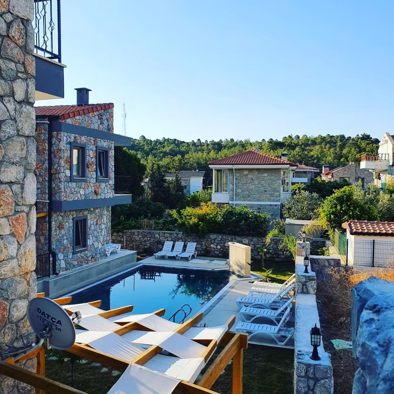 Balkondan Villa Nora havuzu ve taş yapılar