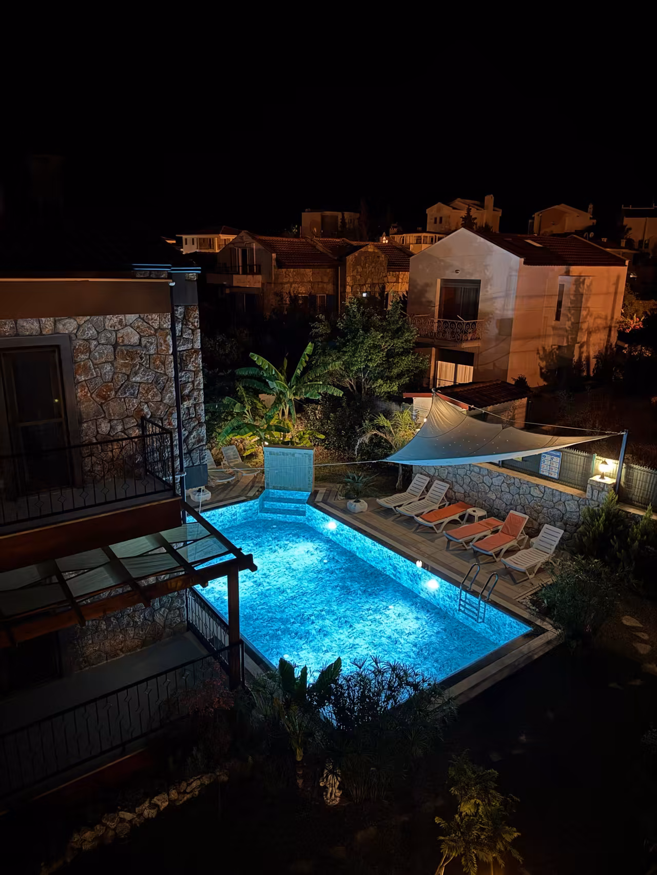 Villa Nora havuzunun akşam ışıkları altındaki görünümü