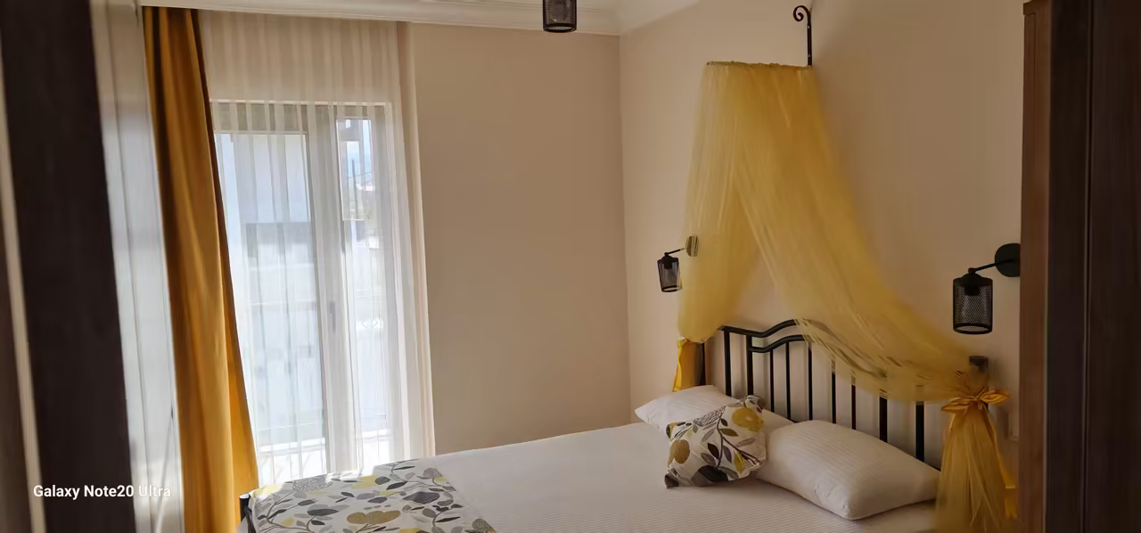 Villa Nora’da gün ışığı alan sade yatak odası